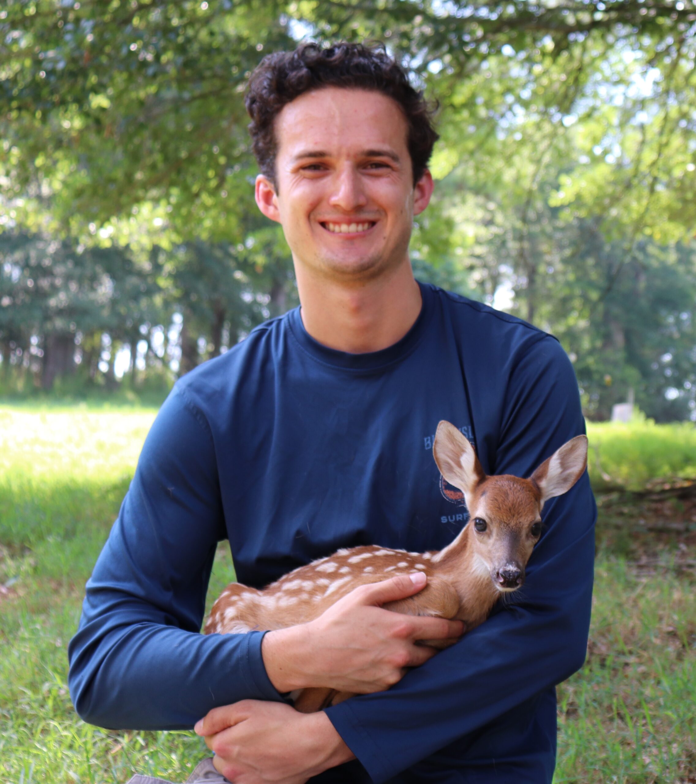 Carson is pictured with a fawn at UGA's captive deer facility in Athens, Georgia. (Photo courtesy of Carson Pakula)