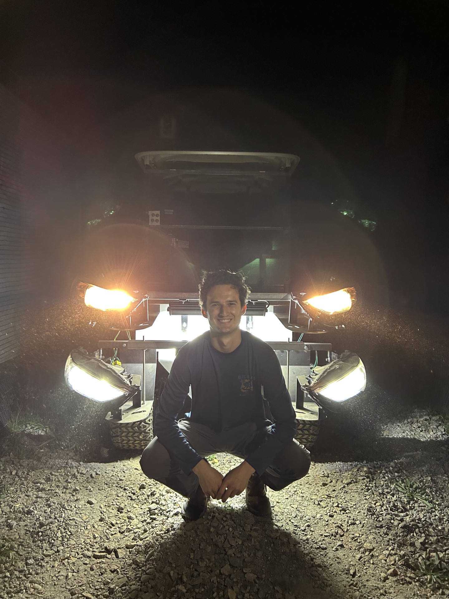 Carson smiles alongside the golf cart used to test how variations in vehicle lighting impacted deer responses to an approaching vehicle. (Photo courtesy of Carson Pakula)